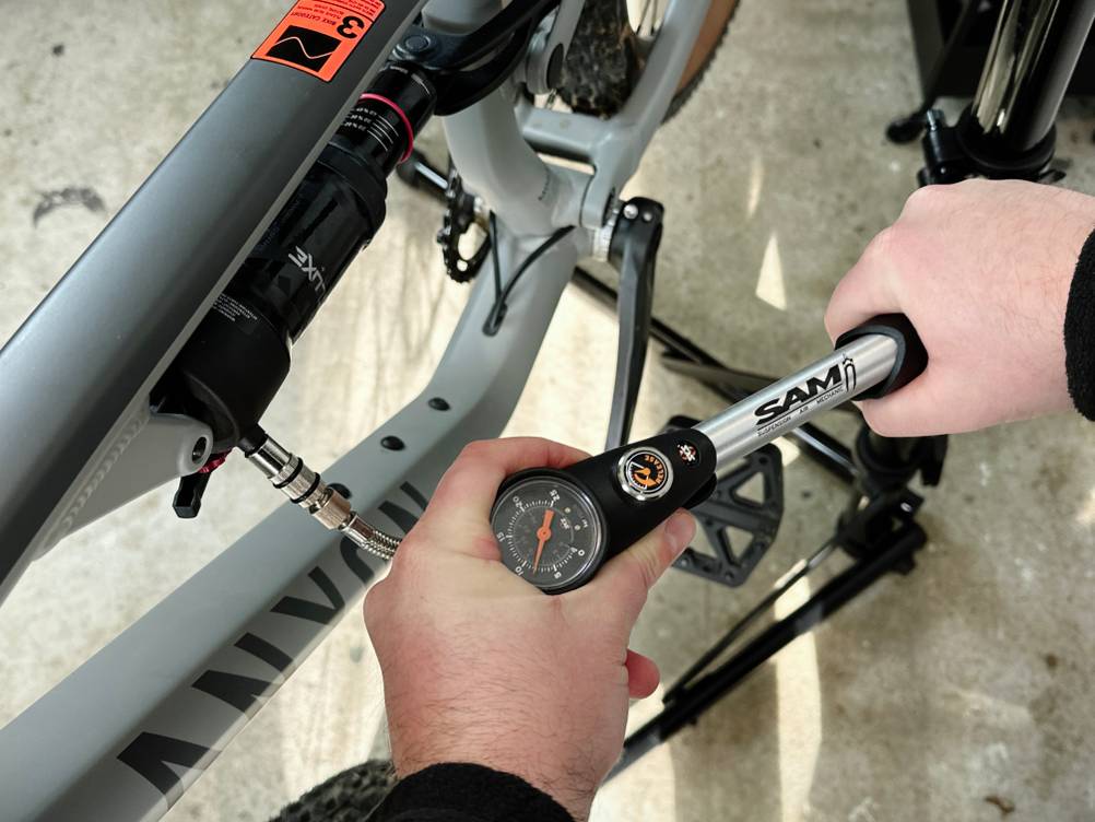 Die SKS-SAM-Pumpe wird an den Dämpfer eines Mountainbikes angeschlossen. Der Druckaufbau erfolgt manuell.