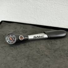 Die SKS SAM liegt einsatzbereit auf einer Werkbank. Das Manometer und der Ablassknopf sind sichtbar.