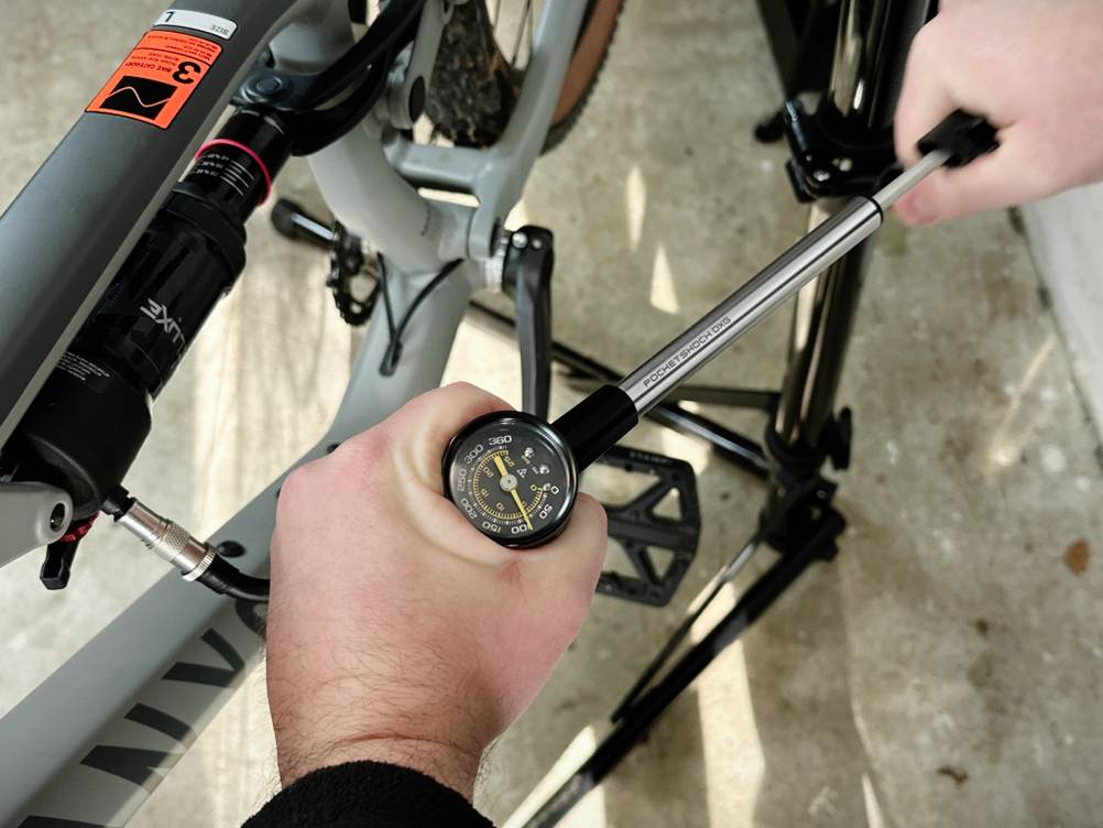 Die Topeak Pocketshock DXG wird aktiv benutzt. Die Hände halten Pumpe und Griff beim Druckaufbau.
