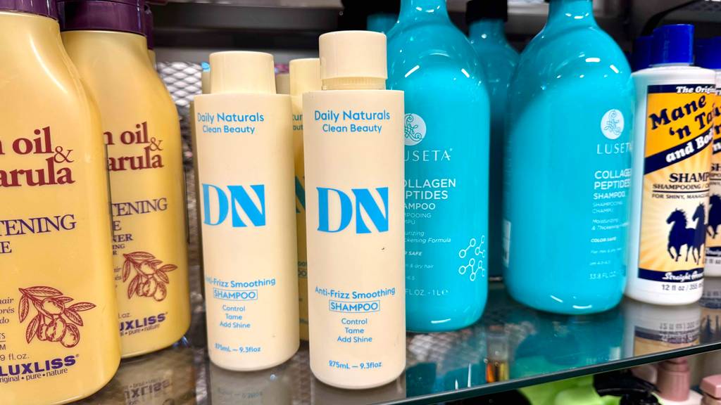 Im Test: Anti-Frizz-Produkte in Kunststoffflaschen stehen nebeneinander in einem Verkaufsregal.