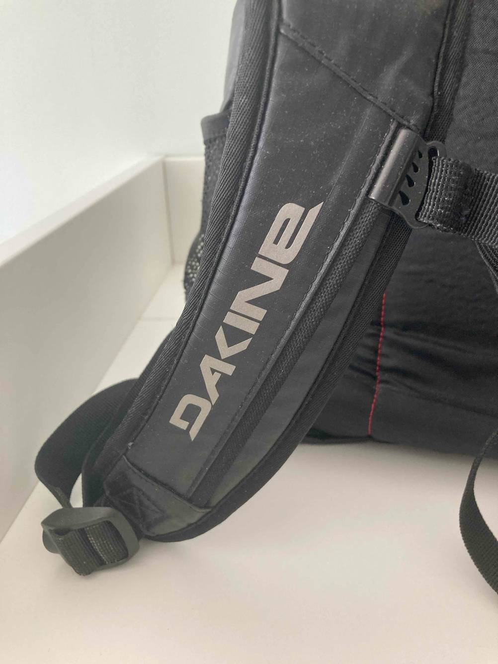 Dakine-Rucksack im Test: Nahaufnahme des Logos auf einem Schultergurt.