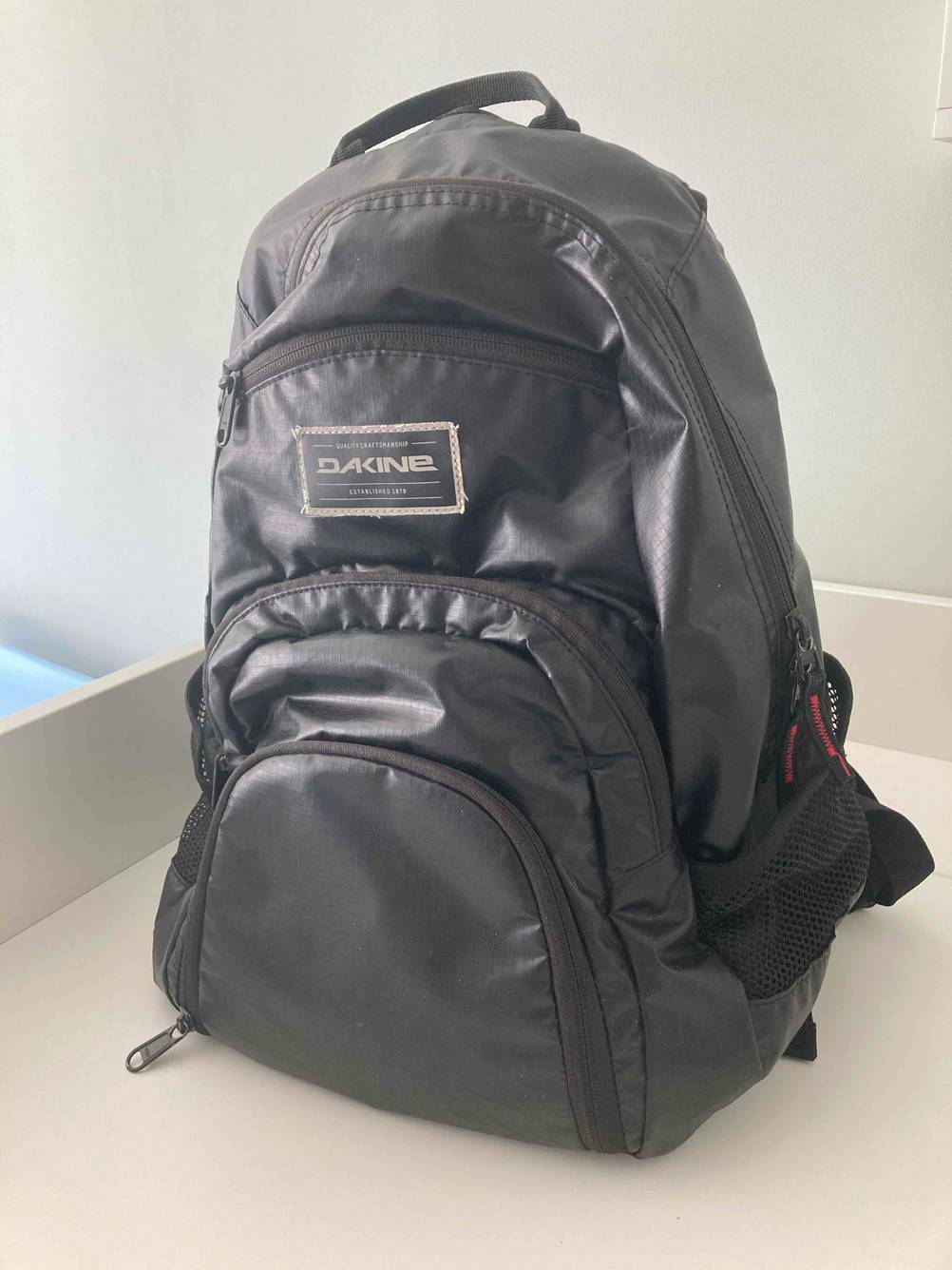 Der getestete Dakine-Rucksack auf einer hellen Fläche von vorne.