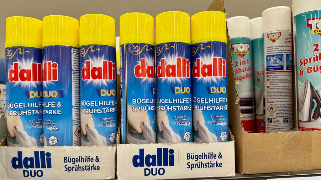 Sprühstärke im Test: Mehrere Dosen unterschiedlicher Marken stehen neben- und hintereinander in einem Regal.