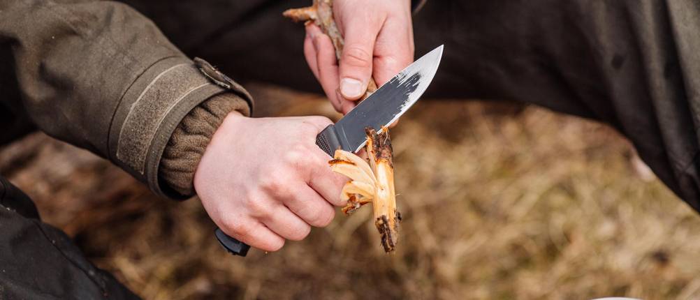Damast-Jagdmesser-Test: Mann schnitzt mit Jagdmesser