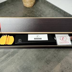 Das Fanteck Gyuto liegt ausgepackt in einer offenen Box. Die Verpackung enthält Zubehör wie einen Klingenschutz, ein Reinigungstuch und einen kleinen Messerschärfer.