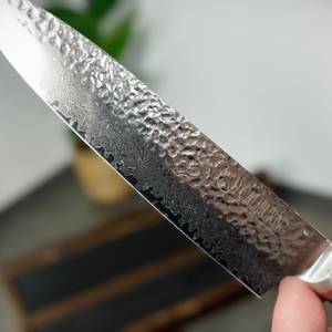 Die Klinge des Schwartzhirsch Caliburn in Nahaufnahme zeigt das feine Damastmuster. Lichtreflexe betonen die Struktur.