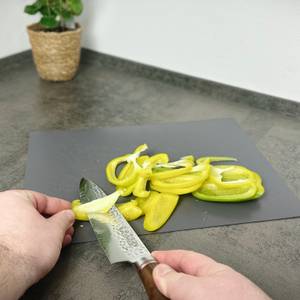 Eine gelbe Paprika wird mit dem Schwartzhirsch Caliburn auf einem Brett zerteilt. Die Streifen liegen bereits in einer Reihe.