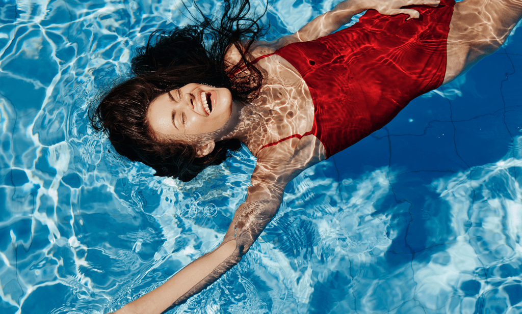 Damen-Badeanzug-Test: Eine Frau in einem roten Badeanzug schwimmt in einem Pool. 