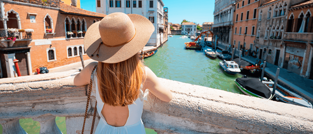 Damen-Sonnenhut im Vergleich: Eine Frau schaut auf einen Fluss, sie träg einen Sonnenhut.