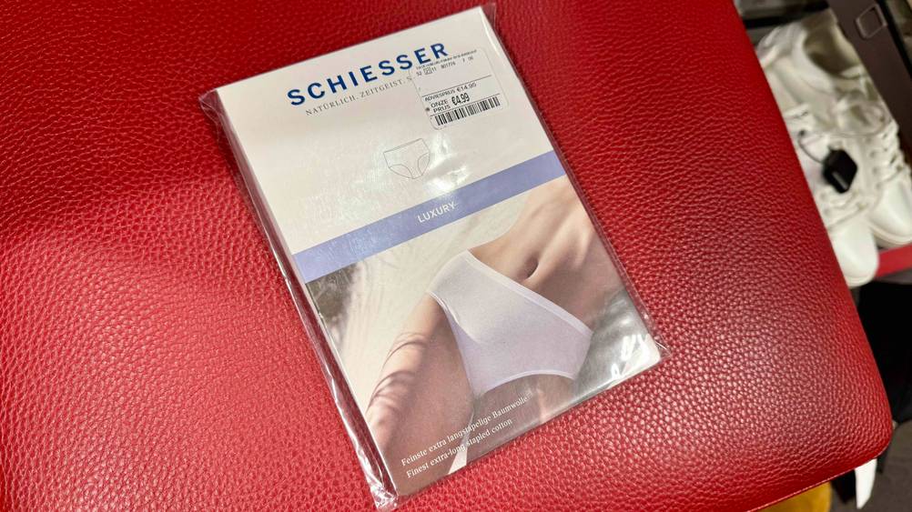 Auf einem roten Polster liegen die Damen-Unterhosen in der Verpackung.