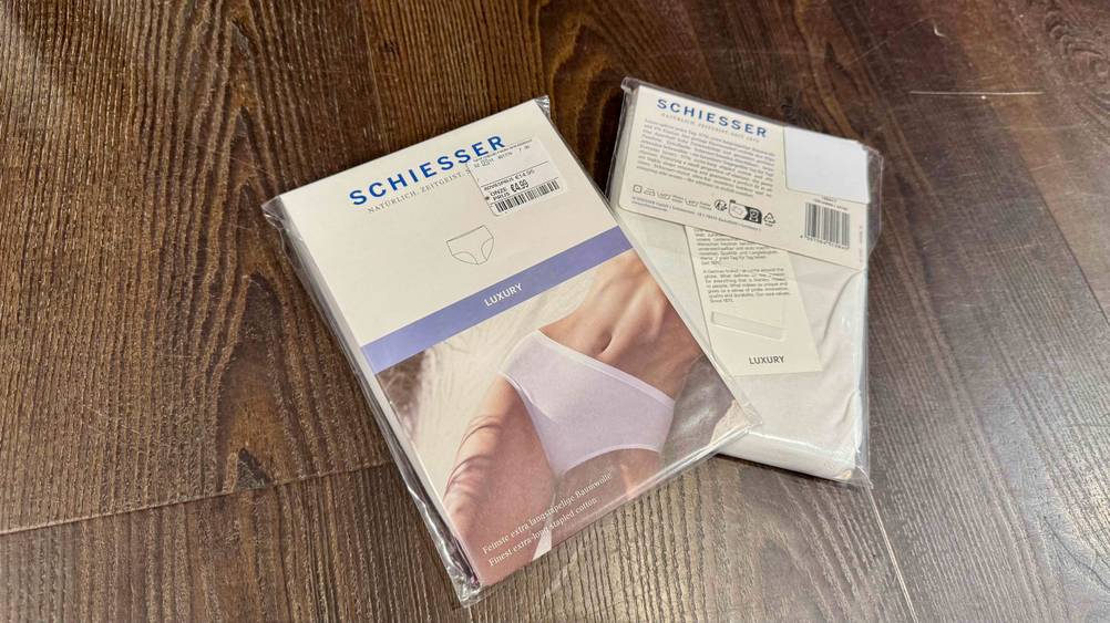 Damen-Unterhosen getestet: Zwei Packungen auf dem Boden, einmal Vorderseite nach oben, einmal Rückseite.