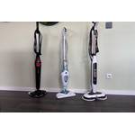 Drei Dampfbesen stehen nebeneinander vor einer grünen Wand