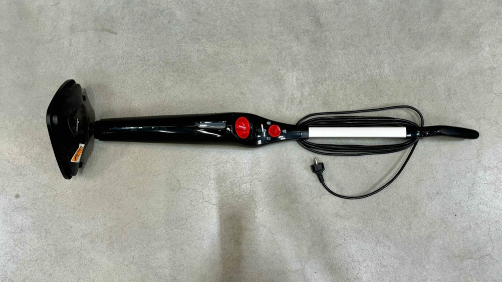 Dampfbesen im Test: Ein Gerät horizontal auf einem Betonboden liegend.