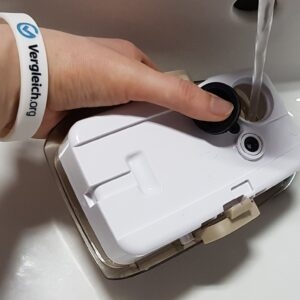 Dampfbesen-Test: Ein Wassertank wird unter einem Wasserhahn aufgefüllt.