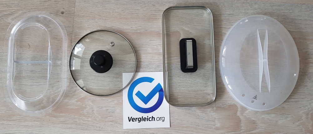 Vier Dampfgarer-Deckel auf einem Tisch mit einem Vergleich.org-Schild.