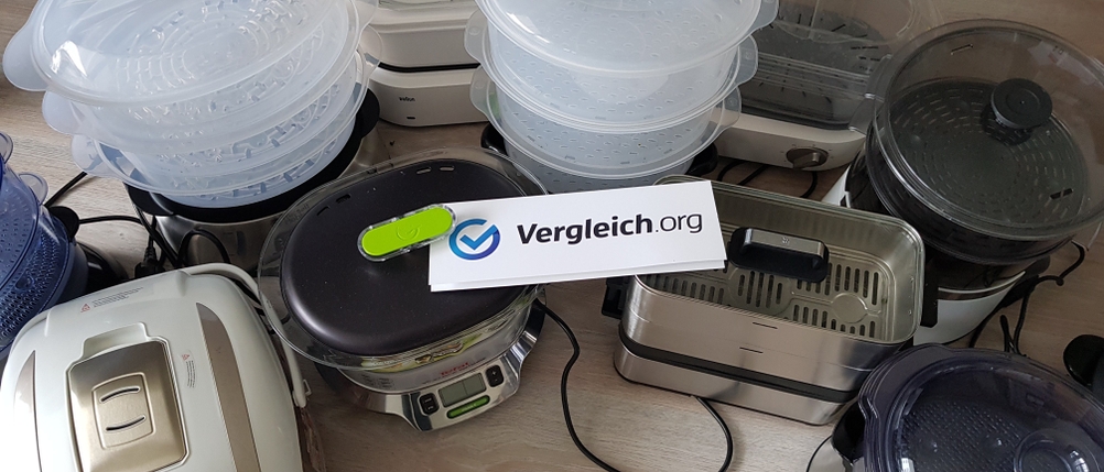 Verschiedene Dampfgarer im Test auf einem Holztisch.