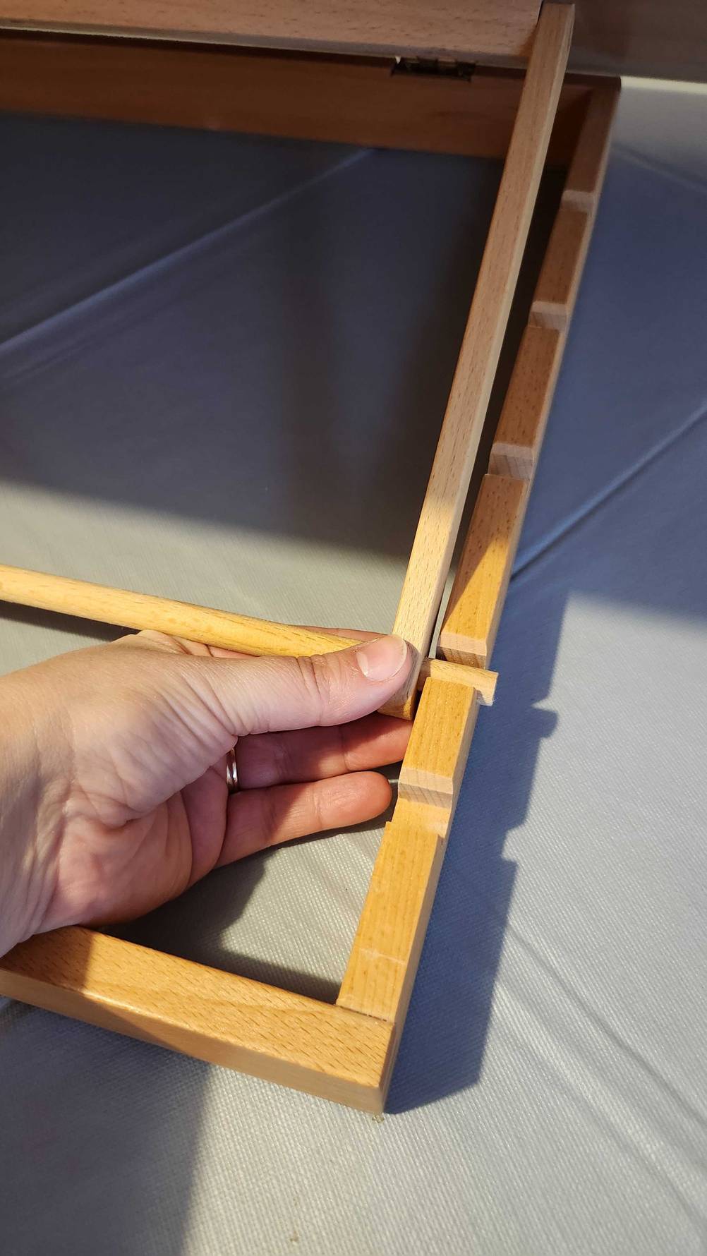 Im Test: Eine Hand befestigt die Staffelei in der Standhalterung.