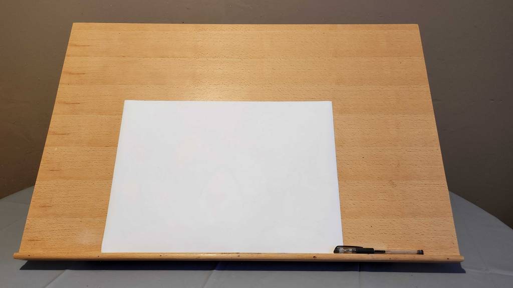 Im Test: Auf einer aufgestellten Staffelei liegen ein Blatt Papier und ein Stift.
