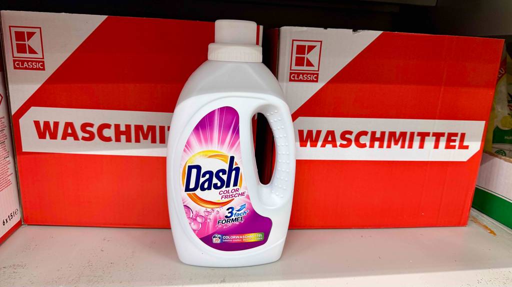 Eine Flasche Dash-Waschmittel steht zum testen vor Kartons mit der Aufschrift Waschmittel.