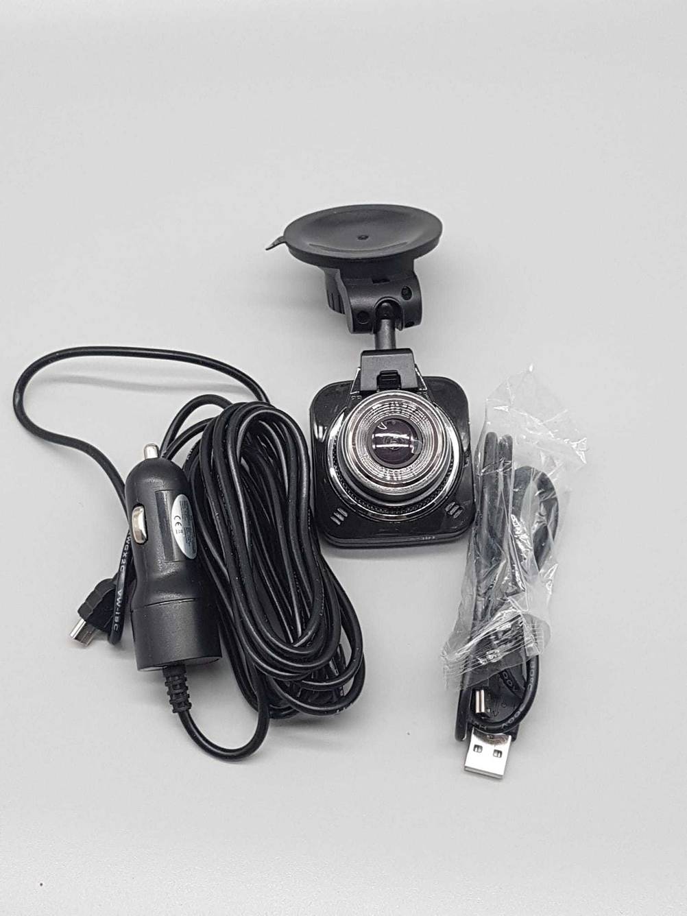 Eine getestete Dashcam mit ihrem Zubehör auf einer hellen Fläche.