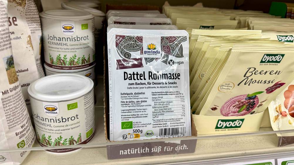 Mehrere Packungen der getesteten Dattelpaste in einem Verkaufsregal neben anderen Produkten.