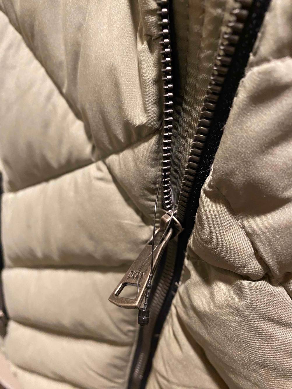 Nahaufnahme des Zippers am Reisverschluss einer getesteten Daunenjacke für Damen.
