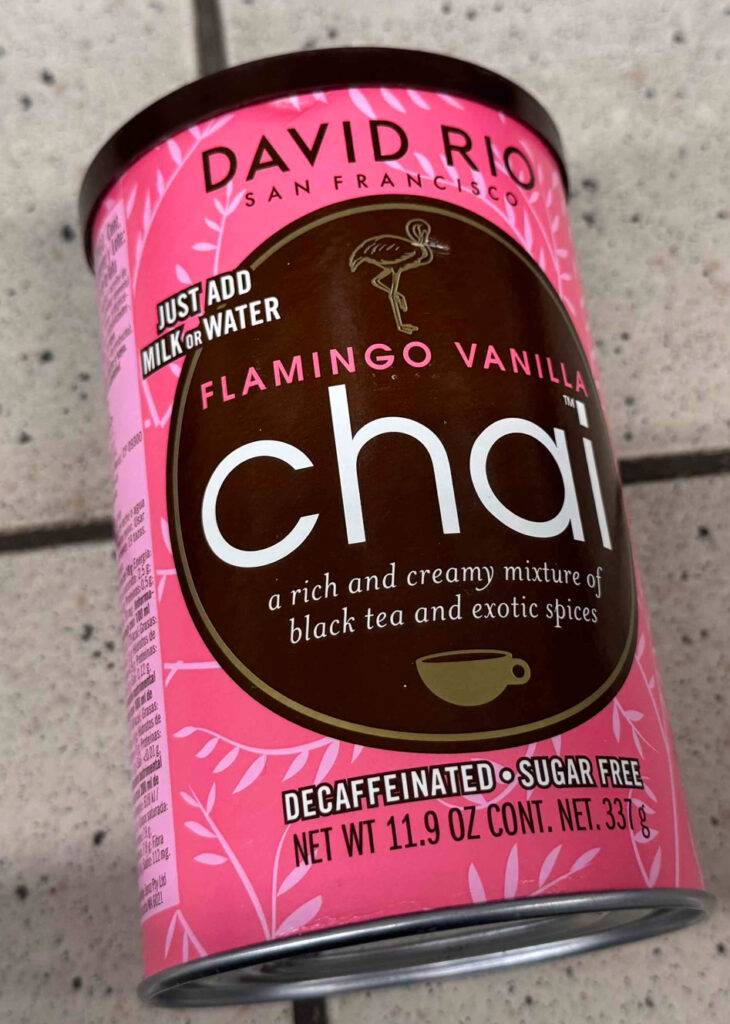 Eine rote Dose mit zuckerfreiem, getestetem Chai-Latte-Pulver liegt auf dem Boden.