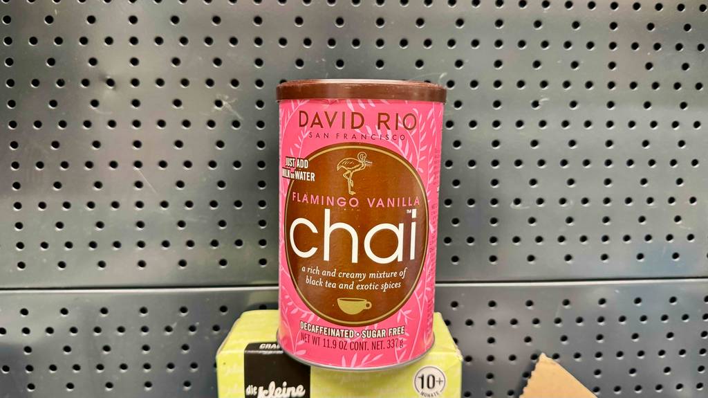 Chai-Latte-Pulver-Test: Eine rote Dose mit Vanille-Instant-Pulver steht vor einer Lochwand.