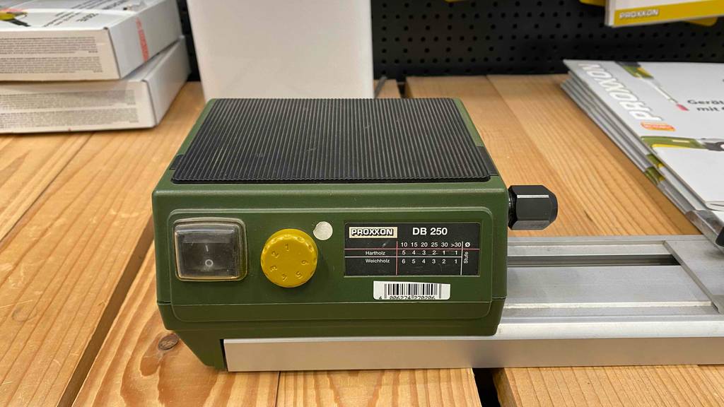 Nahaufnahme einer Proxxon Micro-Drechselbank im Test, mit Fokus auf das grüne Motorgehäuse und dessen Kommandopaneel.