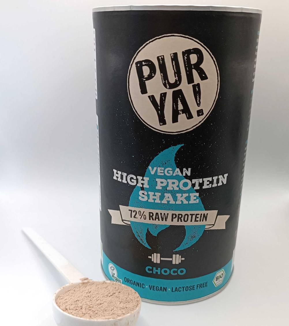 Proteinpulver und Messlöffel mit Pulver.