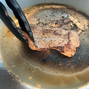 Ein Steak wird in der De Buyer Mineral B Element gewendet