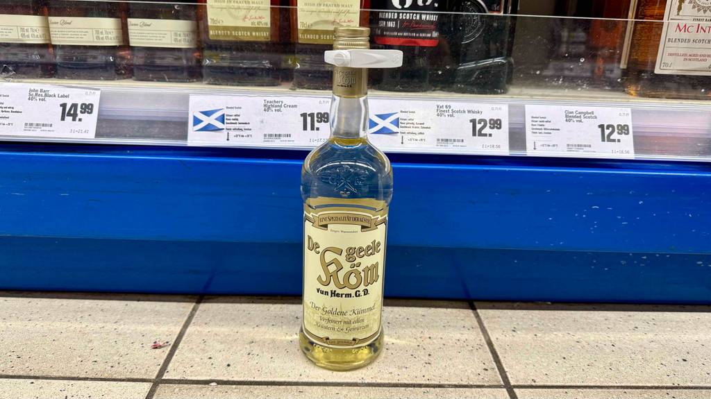 Kümmelschnaps getestet: Eine Flasche steht in einem Supermarkt vor einem Regal mit Spirituosen.
