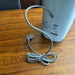 Das Stromkabel des De'Longhi DEL DNS65 liegt auf einem Tisch