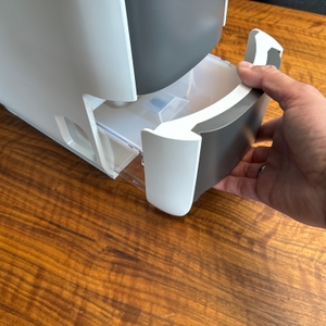 Eine Hand entfernt den Behälter des De'Longhi DEL DNS65