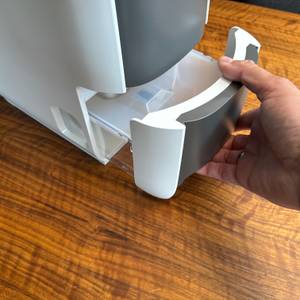 Eine Hand entfernt den Behälter des De'Longhi DEL DNS65