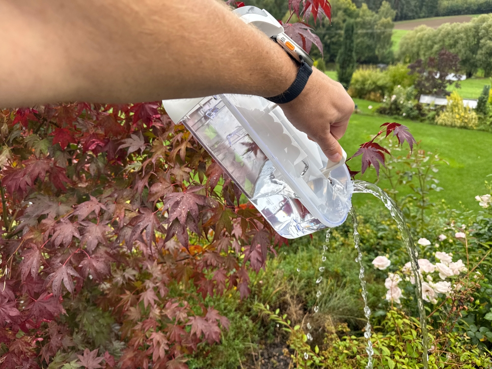 Eine Hand schüttet Wasser aus dem Behälter des De'Longhi DEL DNS65