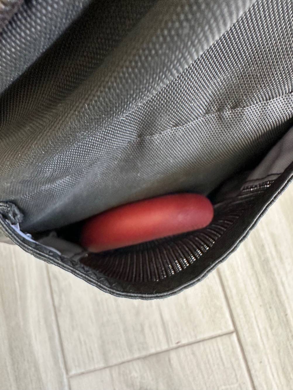 Ein Handtrainer ist zum Testen in einer kleinen Rucksacktasche verstaut, Blick von oben in die Tasche.