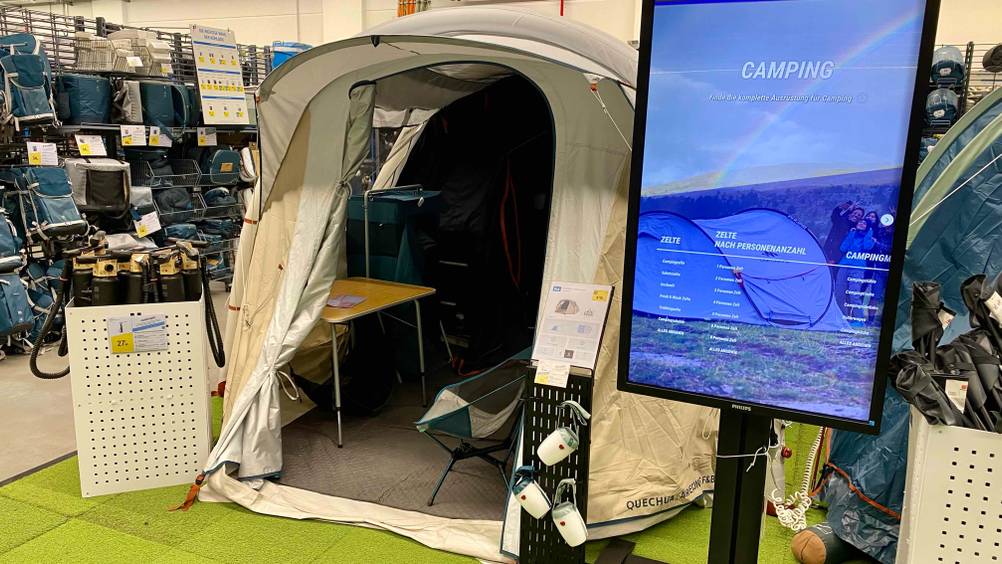 Getestet: Ein 4-Personen-Zelt von vorne mit Blick ins Innere neben einer Digitalen Tafel.