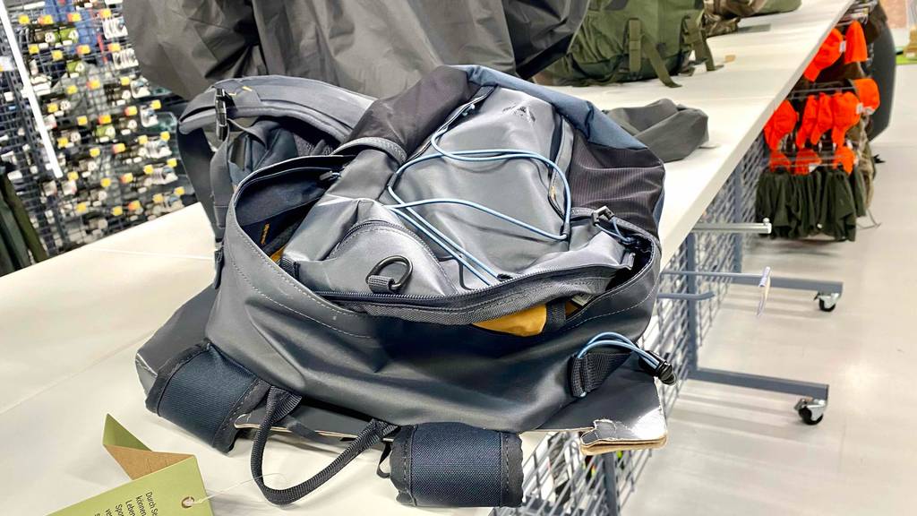 Ein Angelrucksack liegt mit geöffneten Taschen zum testen auf einem weißen Tisch.