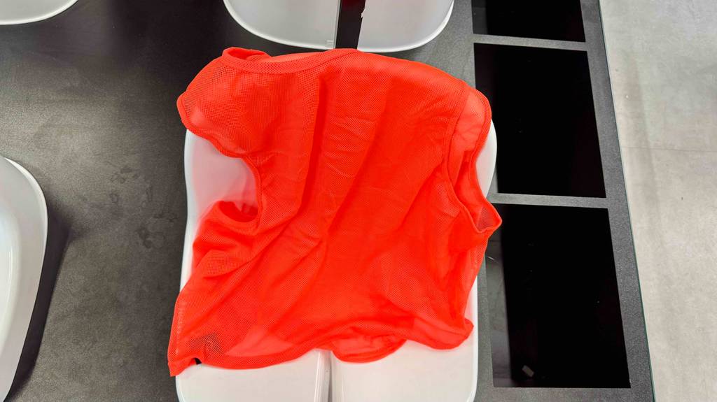 Ein getestetes Fußball-Leibchen hängt mit der Rückseite nach vorn über einer Stuhllehne.