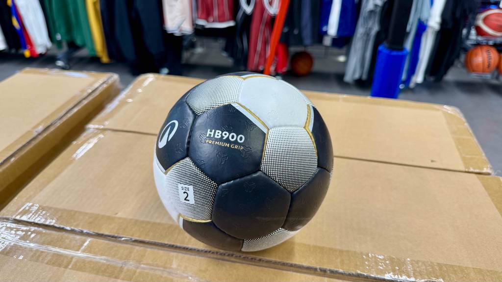Ein getesteter Handball in Größe 2 liegt auf einem Karton.