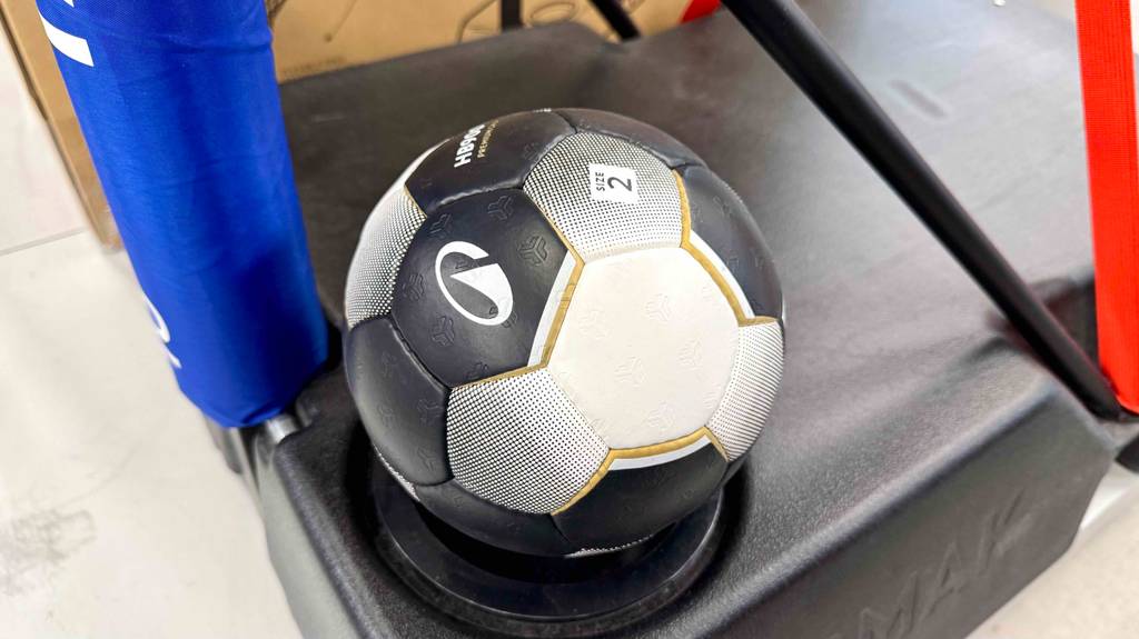 Ein Handball in Größe 2 liegt getestet auf einem Ballpodest.