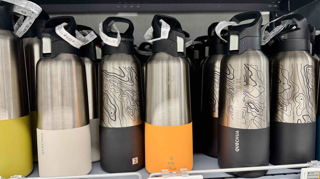 Isolierflasche Edelstahl im Test: Mehrere Flaschen in verschiedenen Designs stehen in einem Regal.
