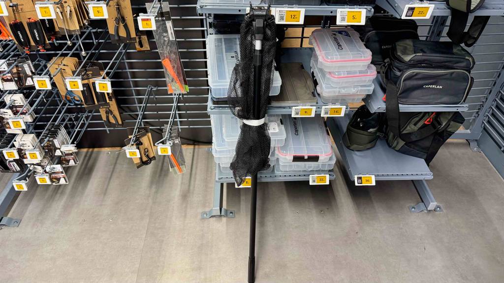 Ein getesteter Karpfenkescher lehnt an einem Regal.