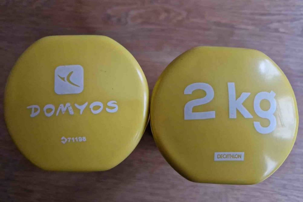 Zwei getestete Decathlon Kurzhanteln in gelb mit 2 kg von oben betrachtet.