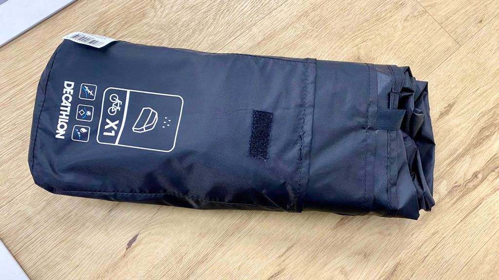 Regenponcho Fahrrad im Test: Verpacktes Produkt auf Holzuntergrund.