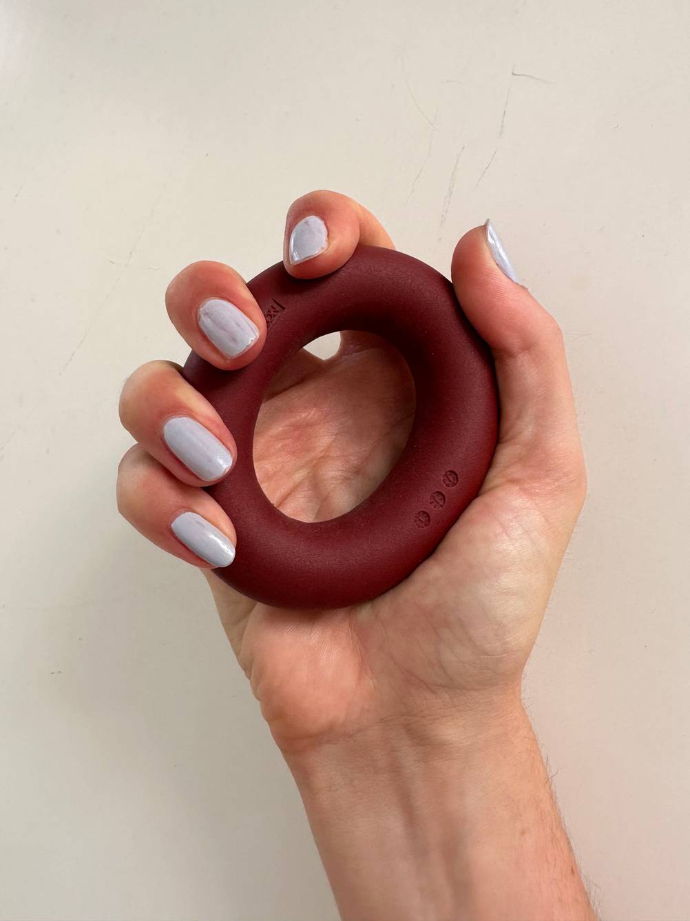 Eine Hand quetscht einen Handtrainer-Ring.