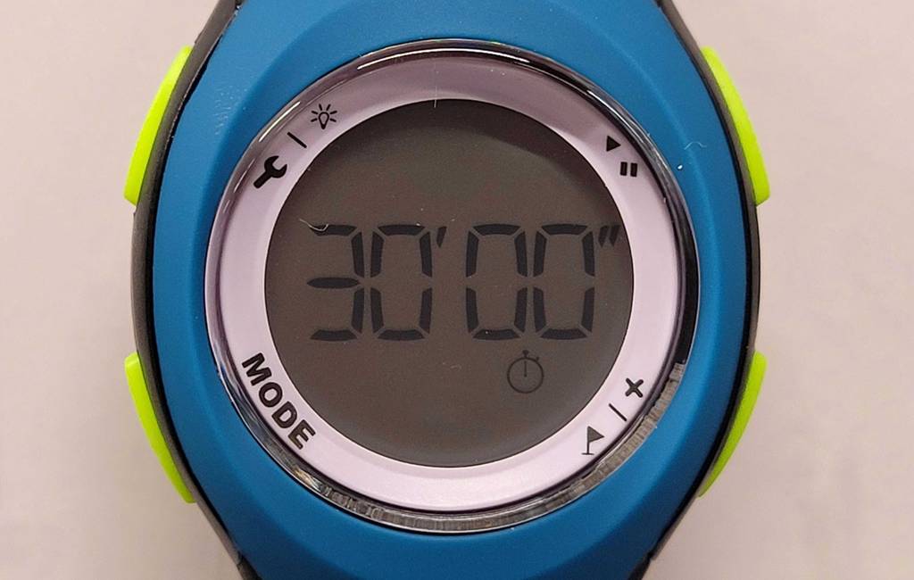 Laufuhr-Test: Nahaufnahme der runden LCD-Anzeige einer Sportuhr im blau-weißen Design inklusive giftgrüner Tasten.