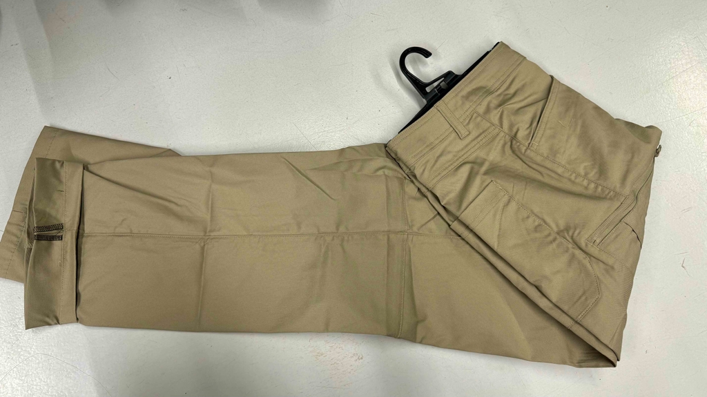 Herren-Wanderhosen-Test: Eine beigefarbene Hose liegt der Länge nach gefaltet auf einem weißen Untergrund.