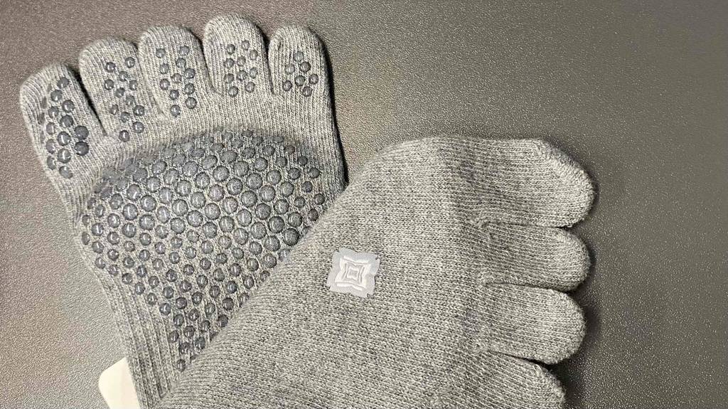 Ansicht der rutschfesten Sohle und des grauen Strickmaterials von Yoga-Socken im Test.